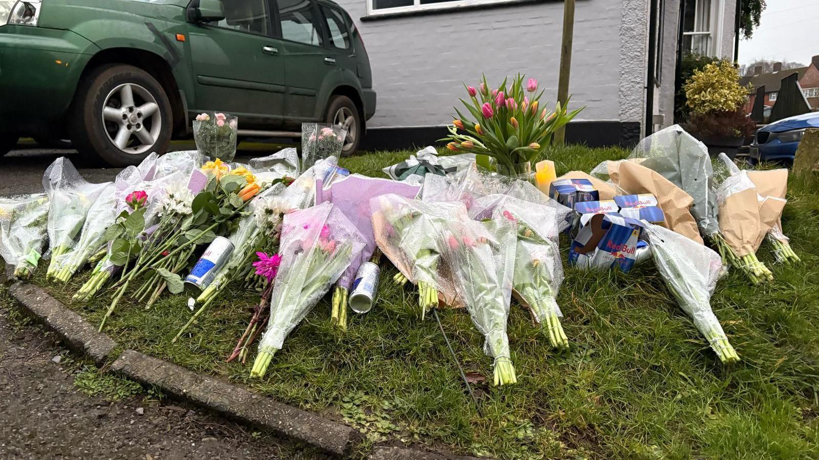 A large selection of flowers on grass in Knockholt outside Three Horseshoes pub