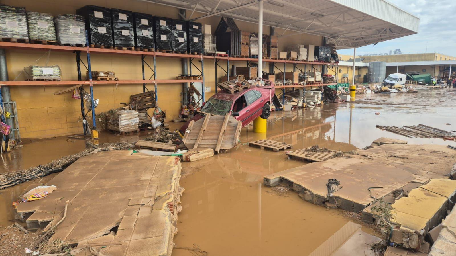 A scene of devastation in Valencia, with collapsed walls, destroyed vehicles and brown water