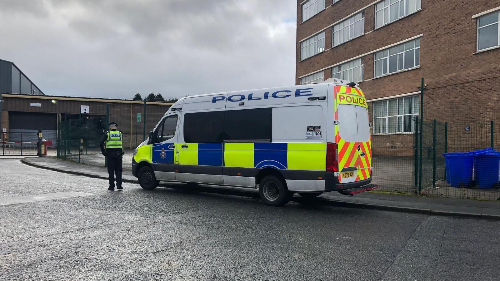 A police van outside industrial premises