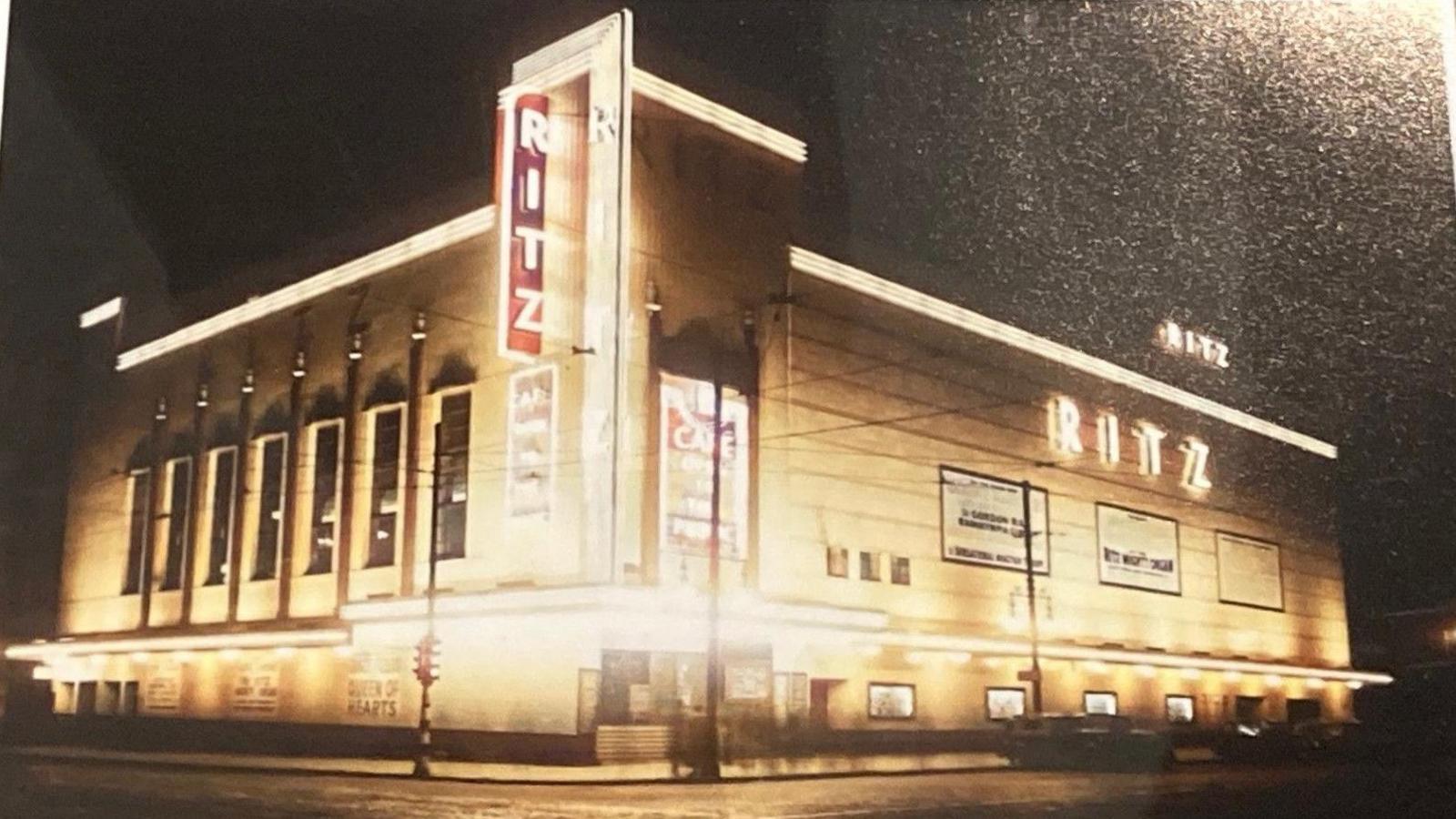 A photograph of the Ritz Theatre illuminated with gold lighting 