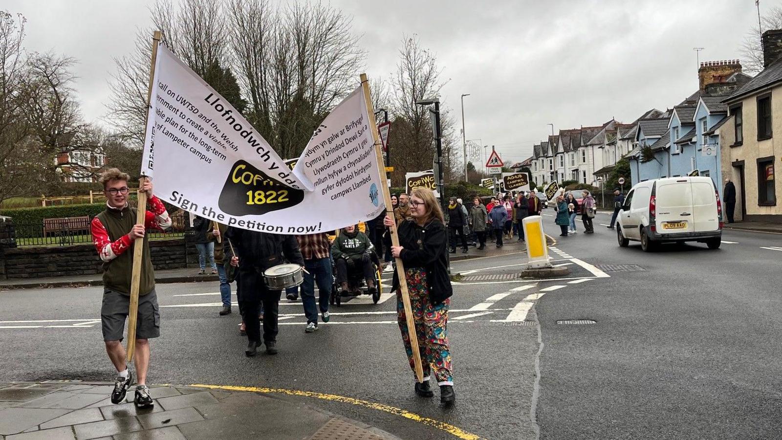 Fe gerddodd nifer o gyn-fyfyrwyr a myfyrwyr presennol o glwb rygbi Llambed i'r campws cyn cynnal rali fer ar dir Prifysgol Cymru y Drindod Dewi Sant.