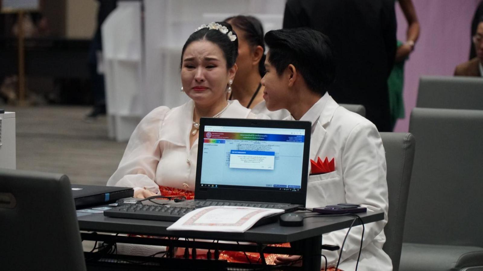 A couple tears up while registering their marriage