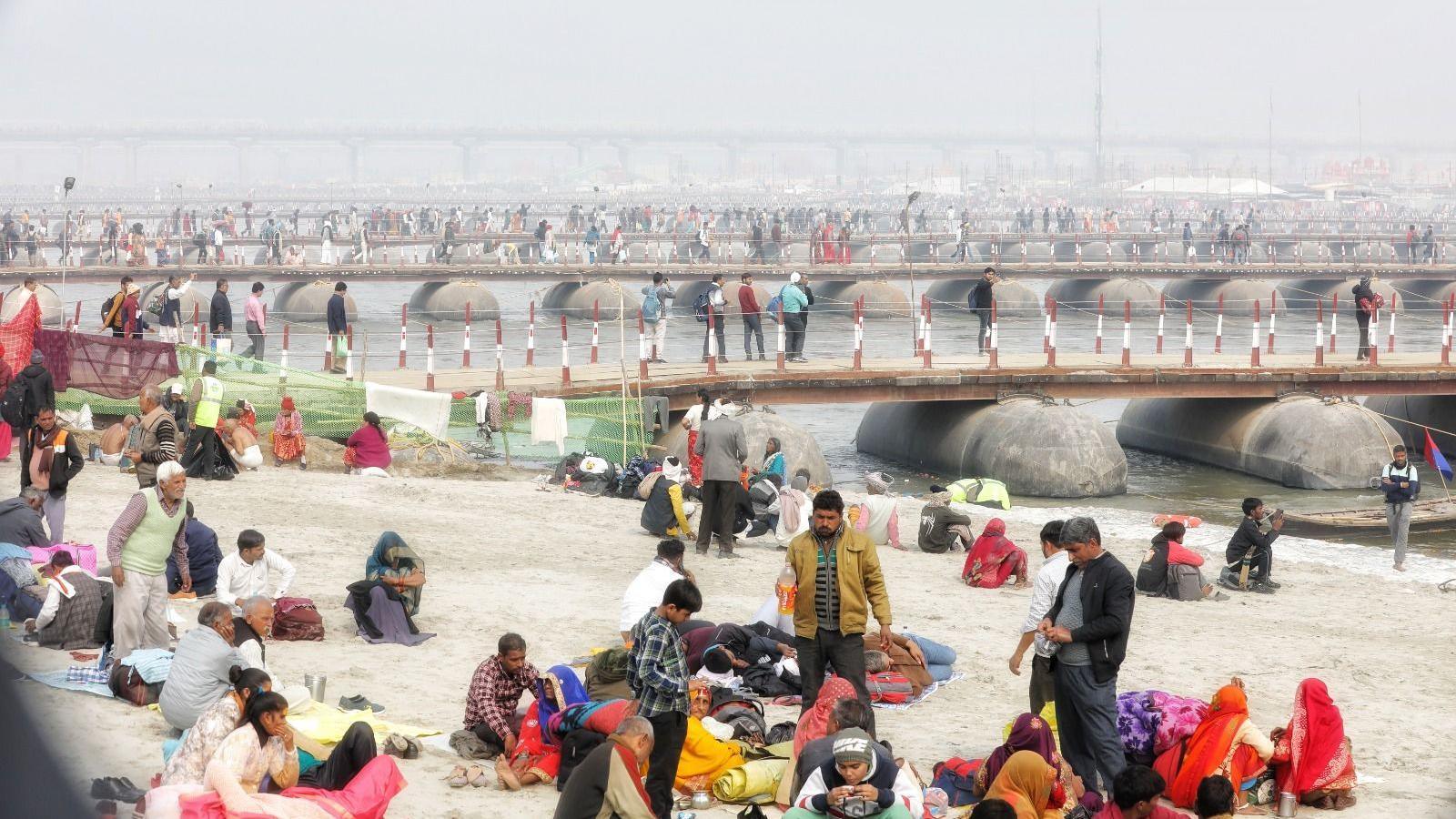 People sit near the banks of Sangam during the Mumbh Mela in Prayagraj 