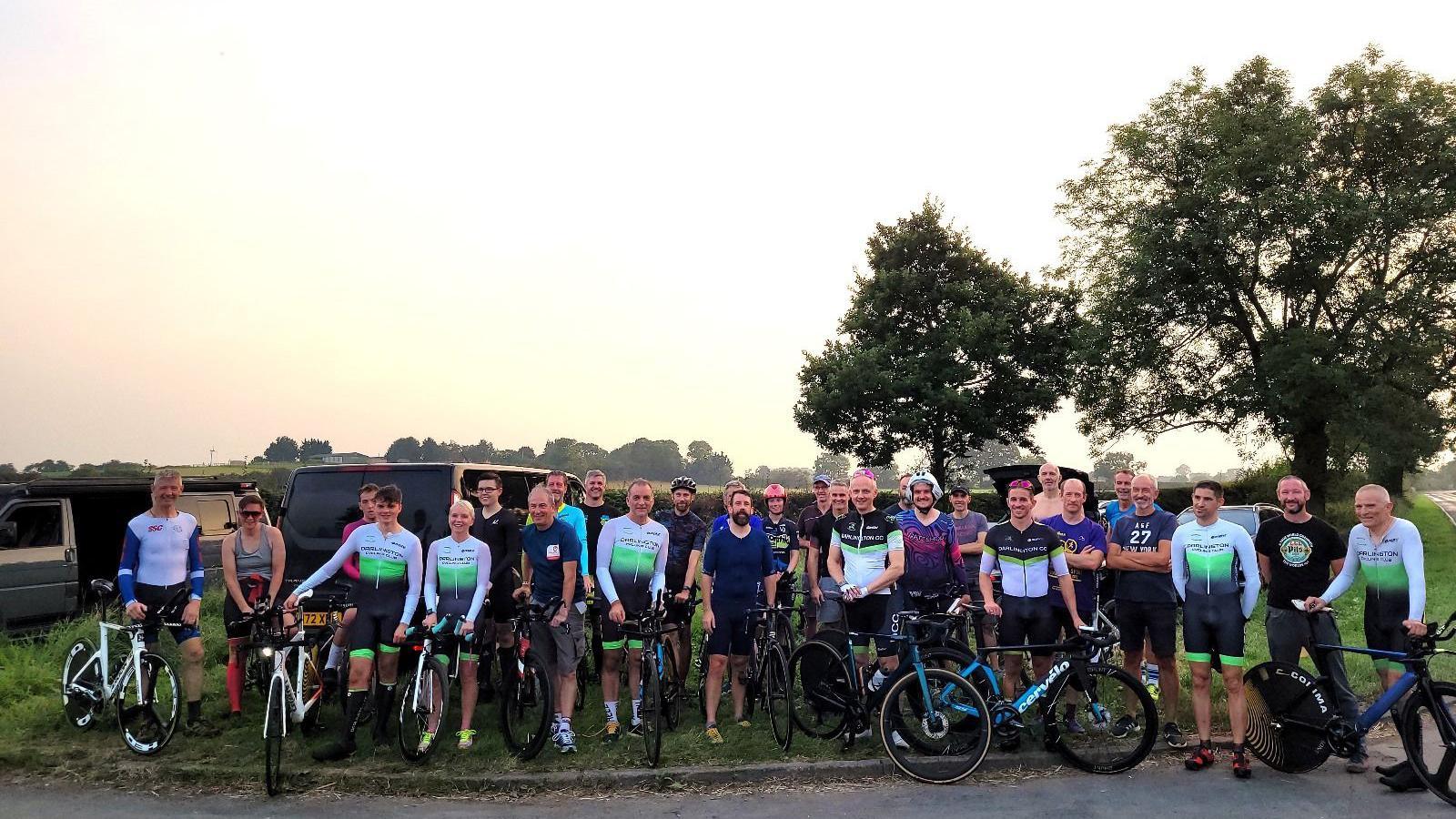 A group of about 20 people all with bikes and quite a few 