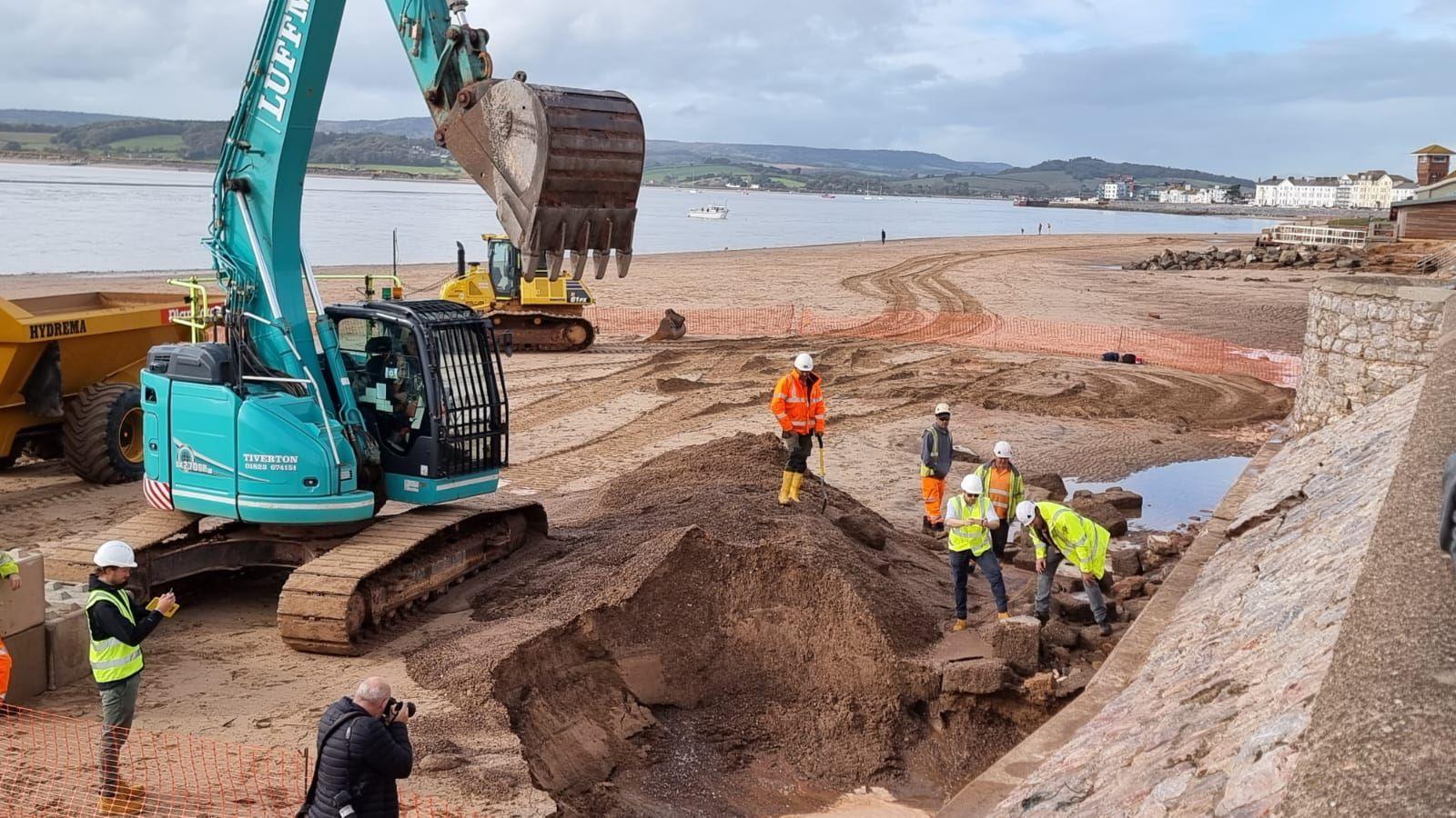 Workmen examining cracks in the sea wall at Exmouth 