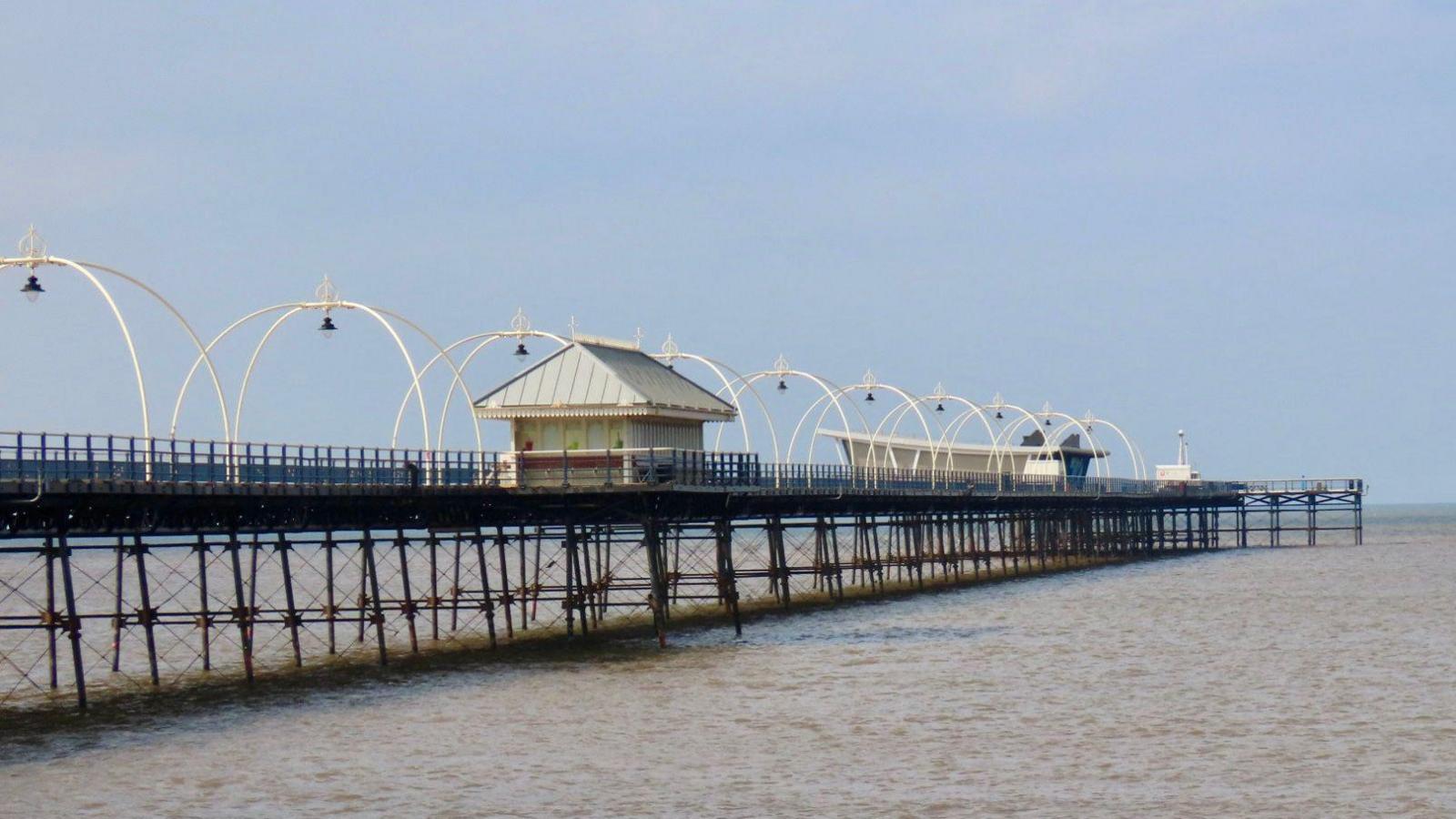 Southport Pier, photographed on a hazy, sunny day with calm seas.