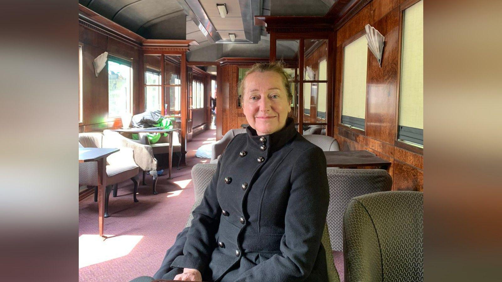 Rose Marian Finn, dressed in Victorian clothing, on set inside a Victorian train carriage