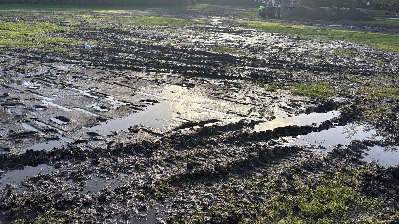 There a large areas of mud and water in a park.