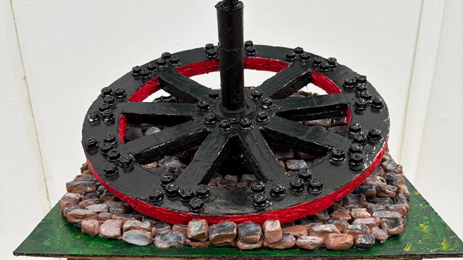 Sculpture of a red and black wheel.