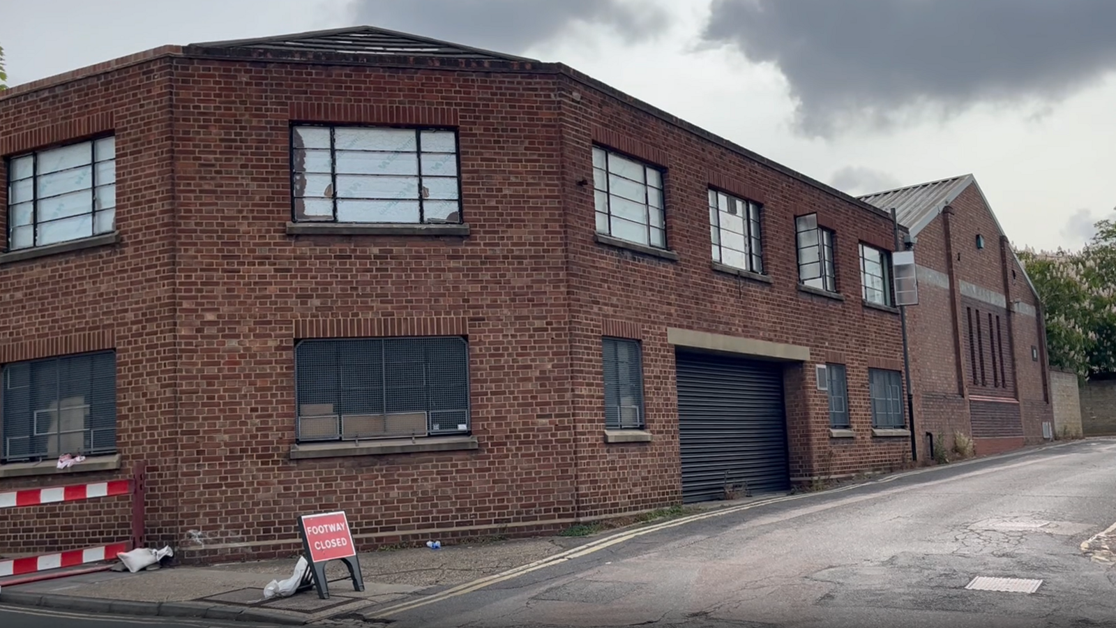 The museum store room on Charles Street. It is a red brick building across two storeys. Some of the windows have been boarded up while others have been opened. The pavement has been cordoned off.