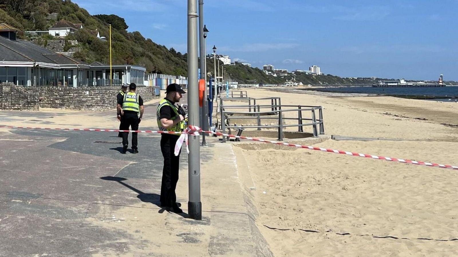 Police officers on sandy beach