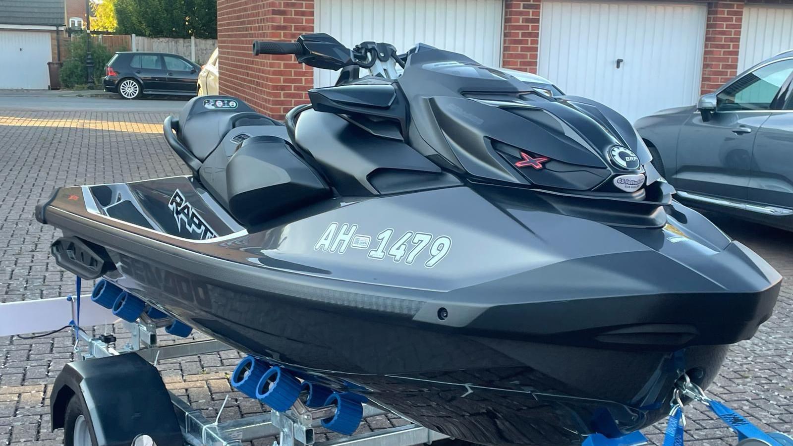 A black personal watercraft on a driveway.