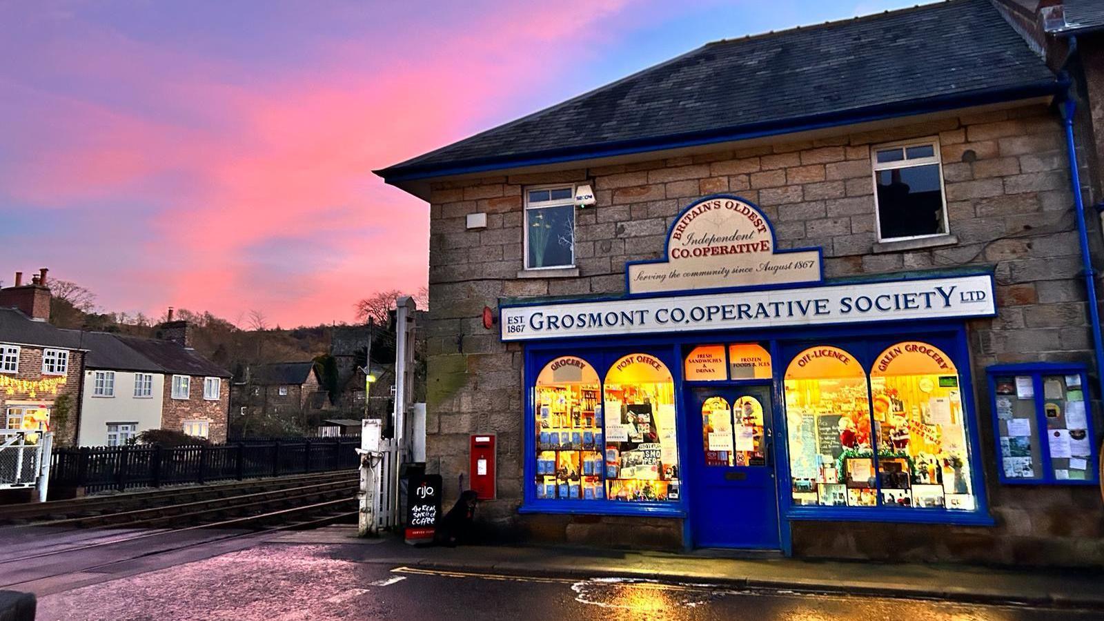 Exterior picture of the Grosmont Co-operative Society with the sun setting behind it