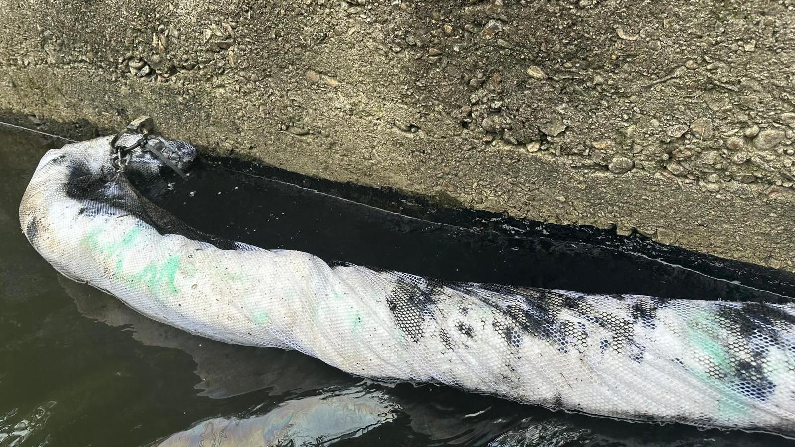 A boom in the river gathering the oil in one area