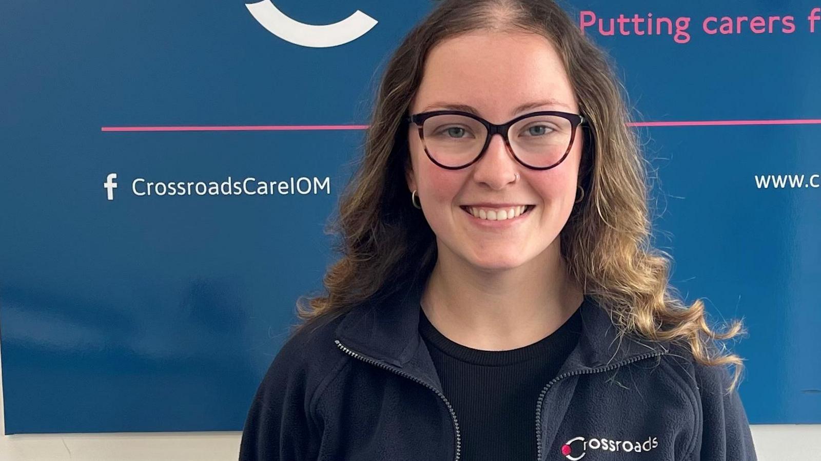 Carlie Maddrell in front of a Crossroads sign