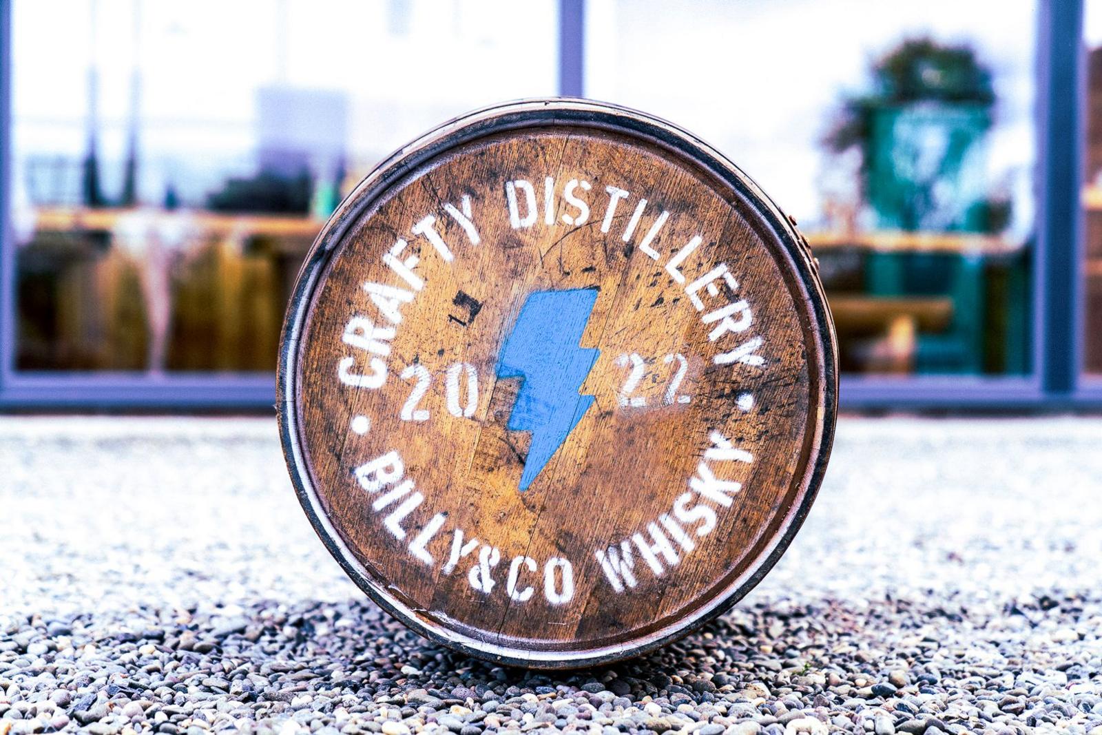 A whisky barrel on its side with the Crafty Distillery logo