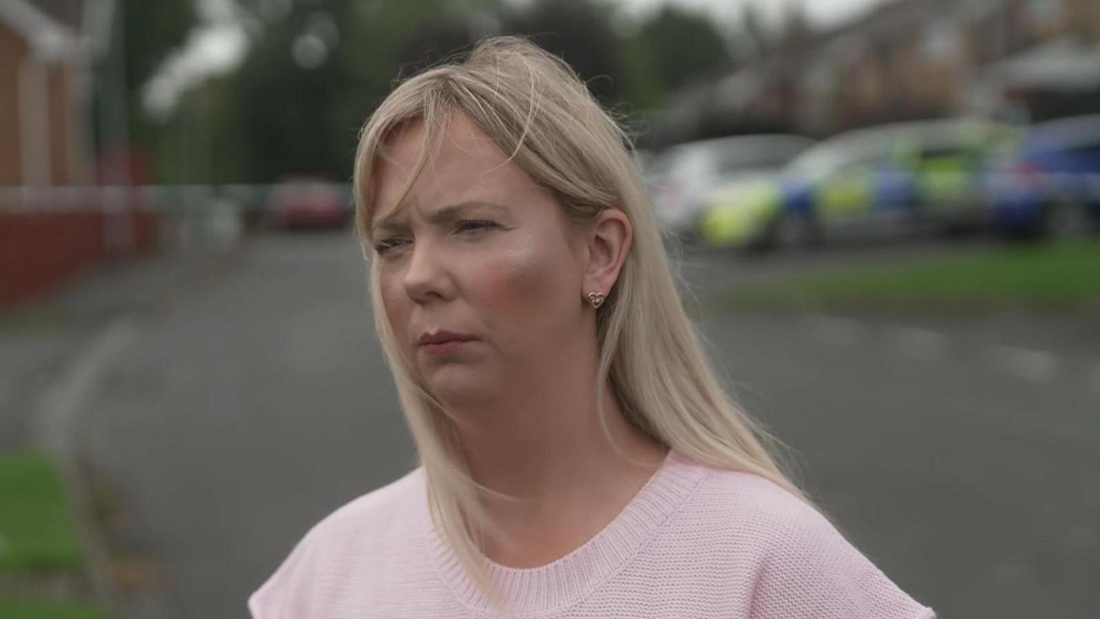 Catherine Nelson. She has long blonde hair, wearing a pink short sleeve knit top.