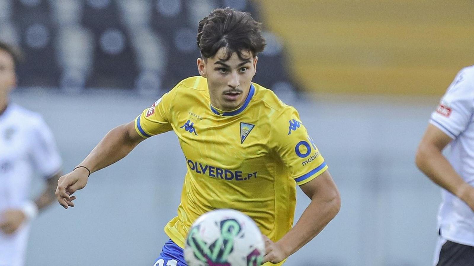 Rodrigo Gomes runs with the ball wearing Estoril's yellow shirt 