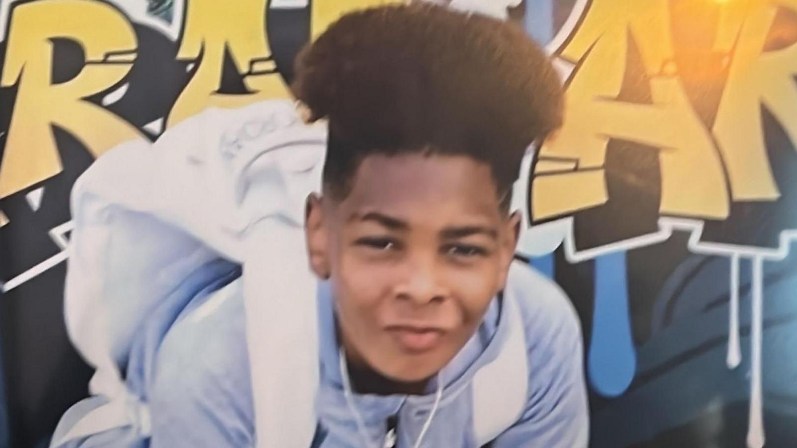 Kelyan in a blue hoodie and wearing a white rucksack.