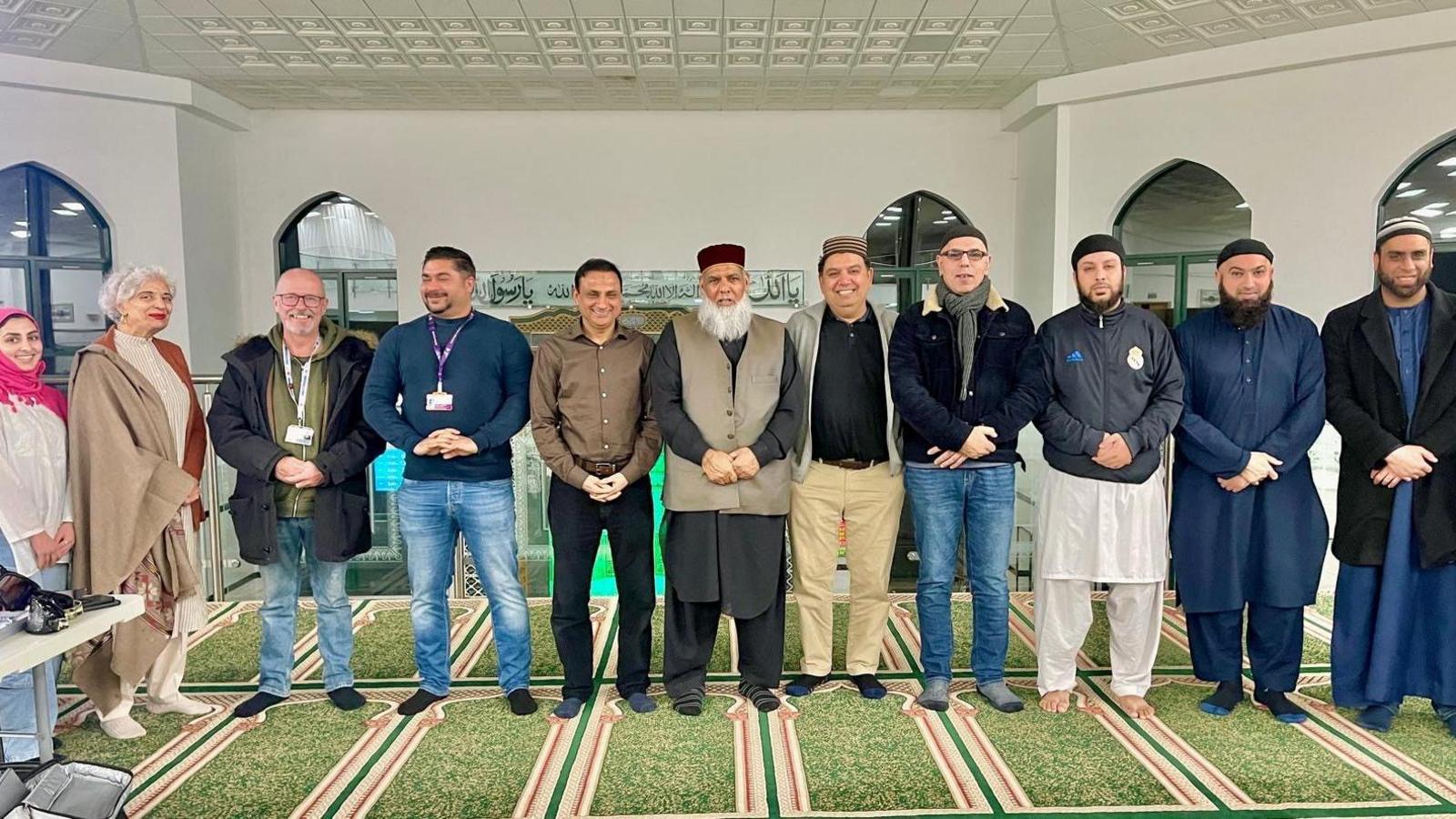 Group of people standing in a line at the Mosque event