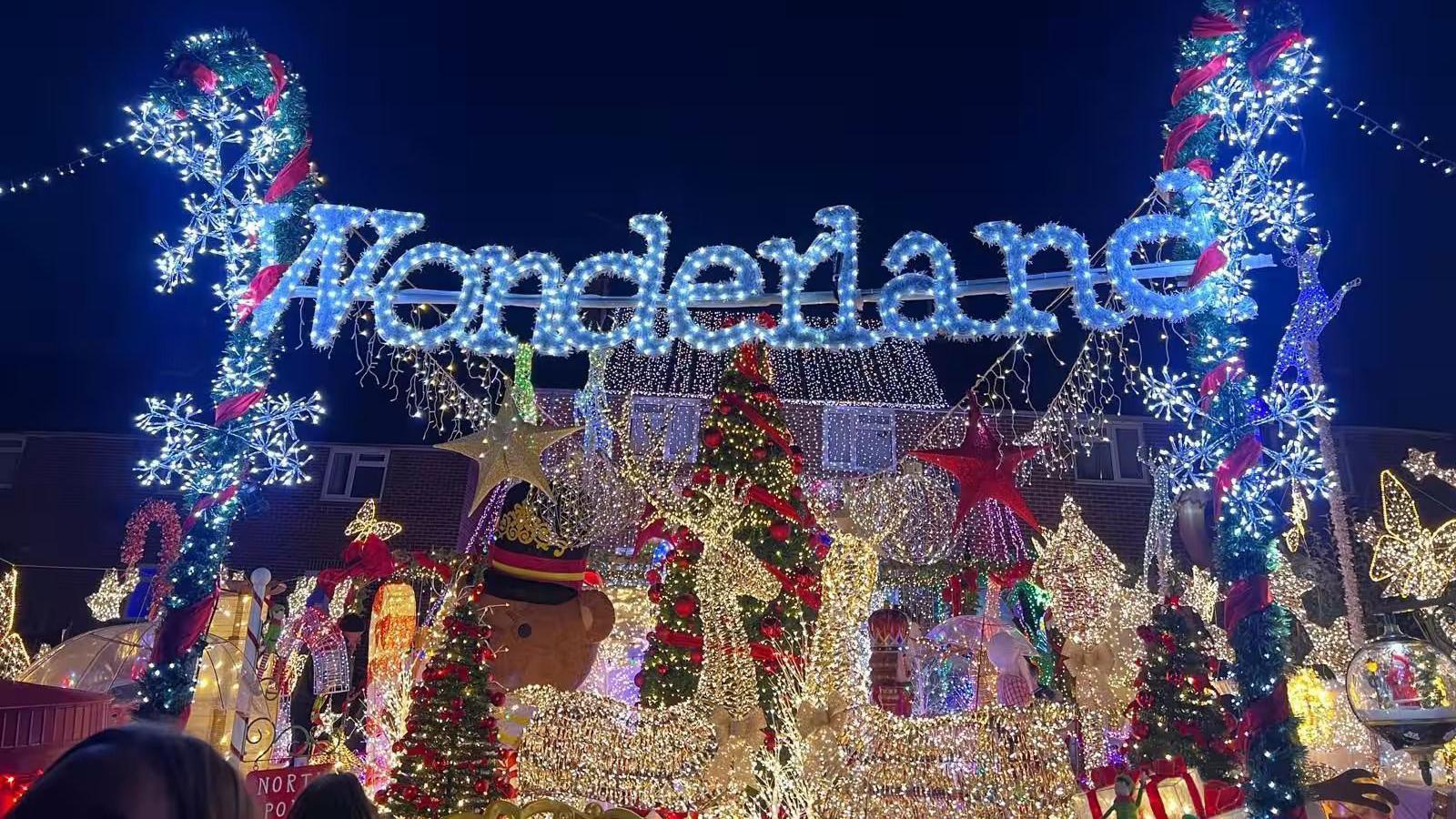 Christmas lights on a house. There is a sign above which says "Wonderland".