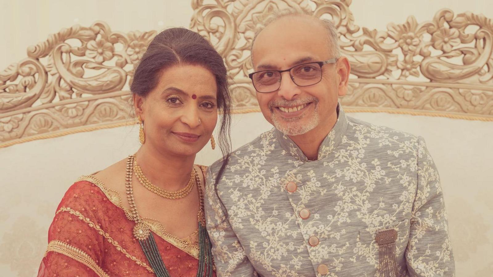 Two people are pictured close to each other, smiling.