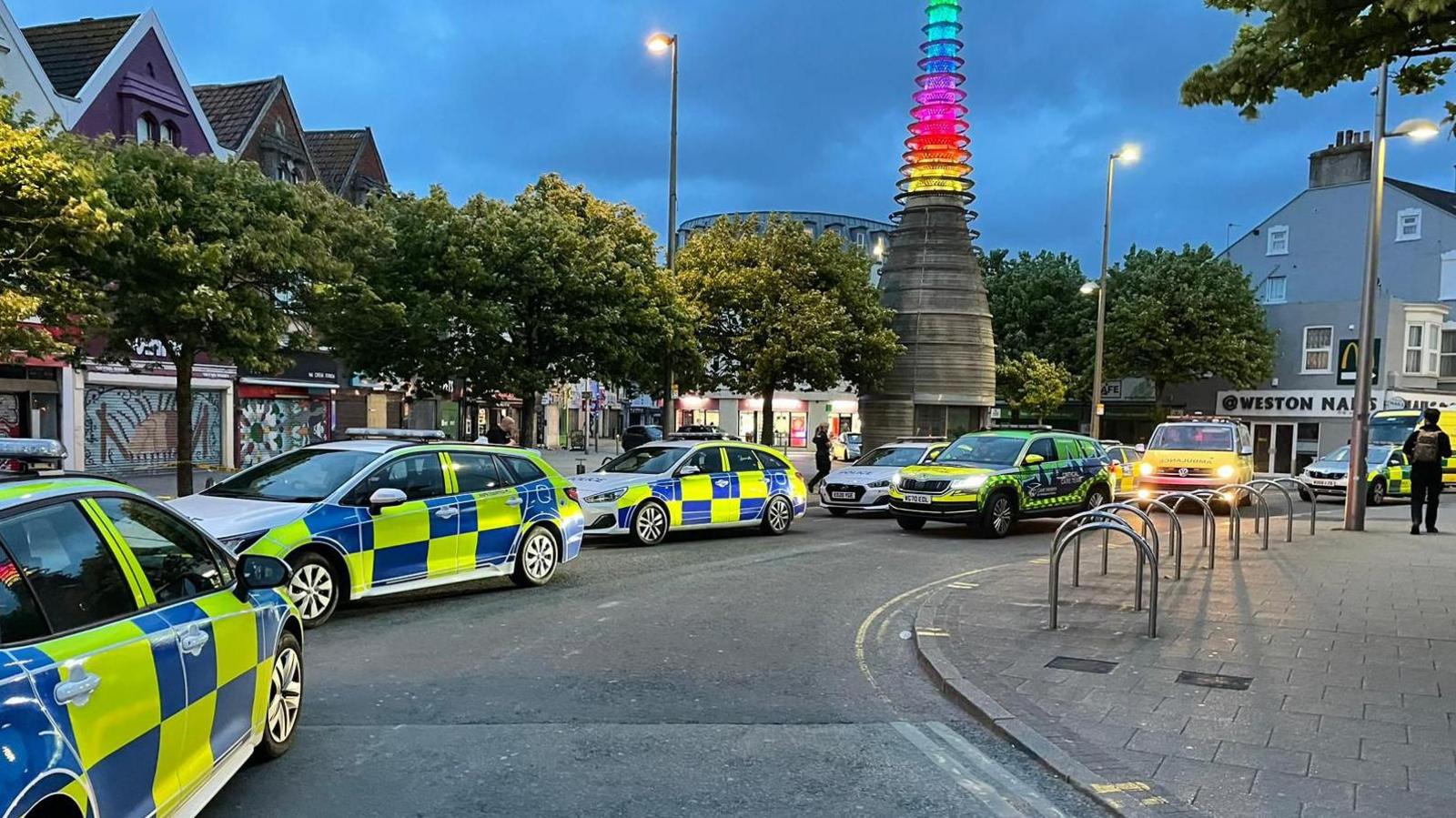 Police cars lining up along street at dusk