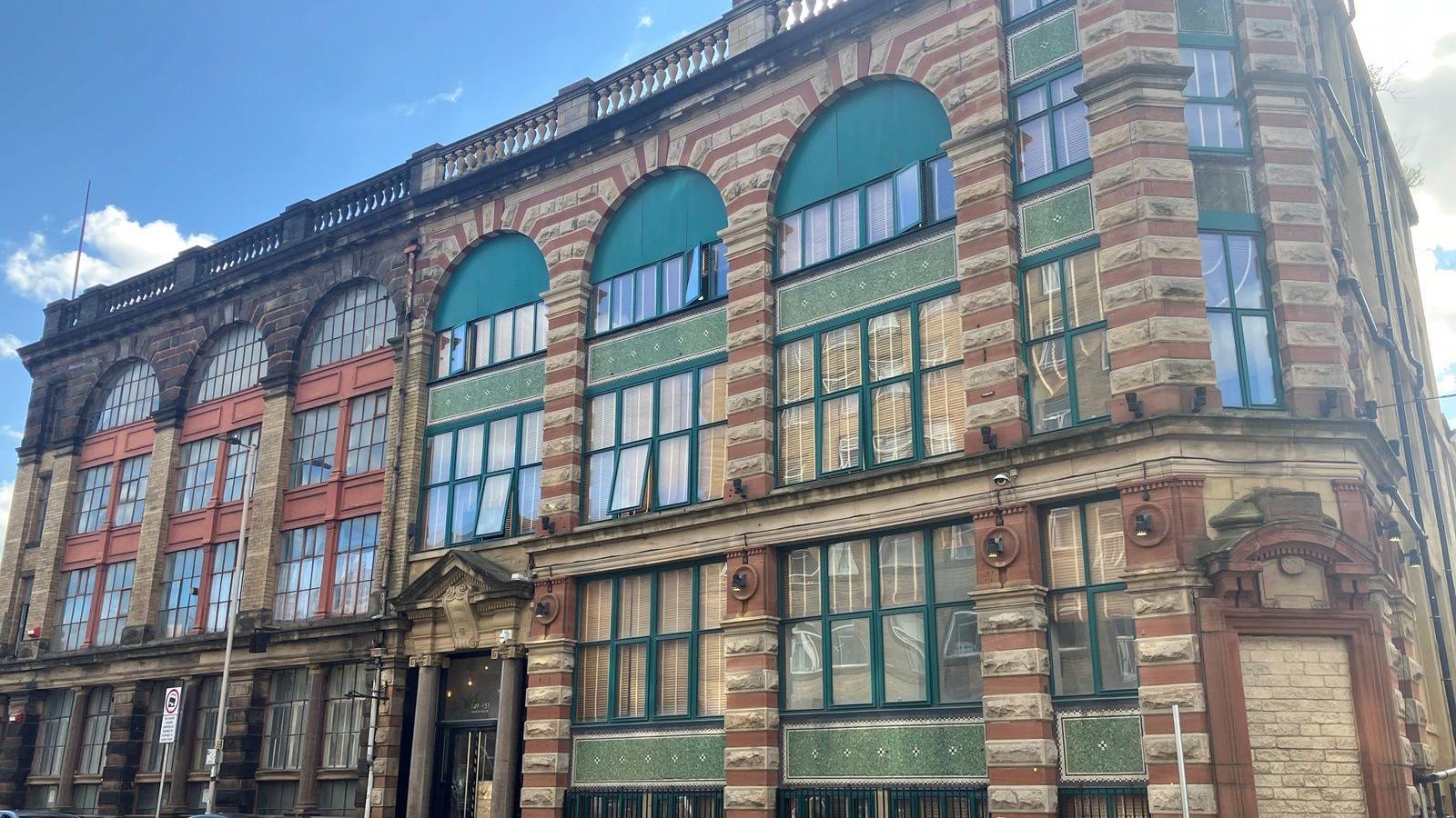 Lennon House in Bradford. Pictured is a colourful tall two-storey building with green window frames