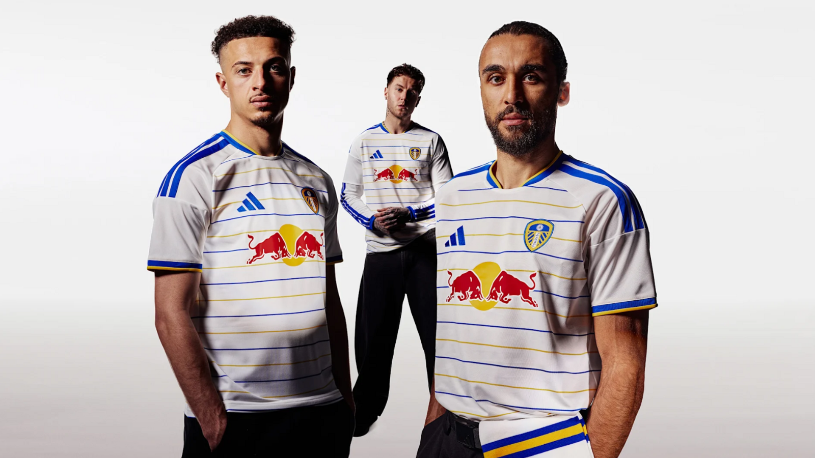Dominic Calvert-Lewin, Ethan Ampadu, and Joe Rodon wearing the new Leeds United home kit, a white shirt with horizontal blue and yellow stripes