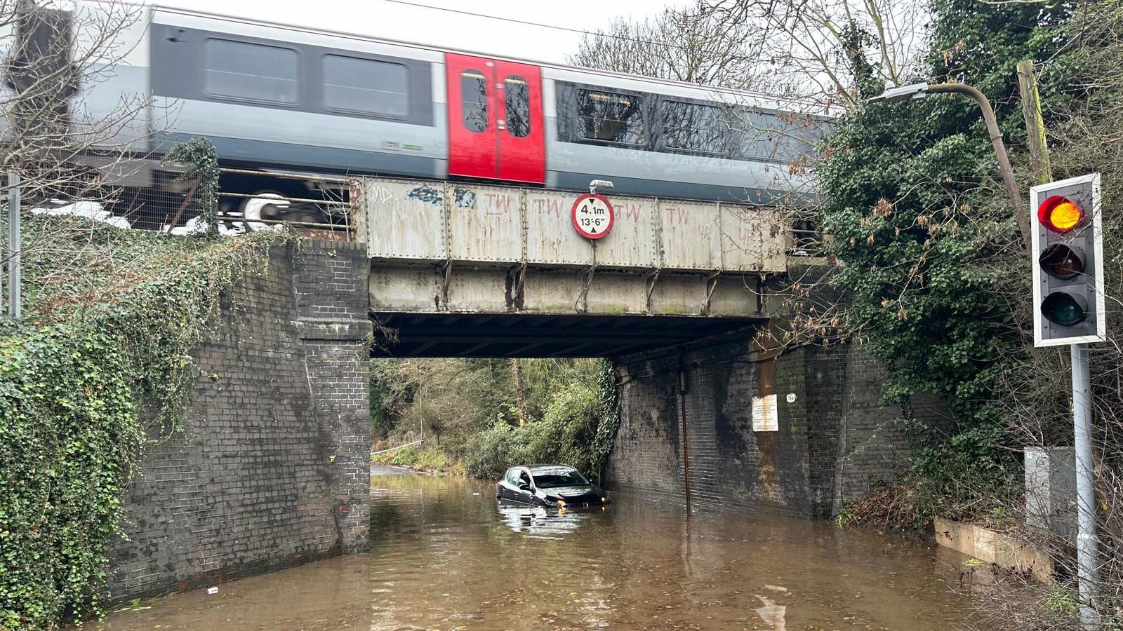 Car stuck under railway bridge