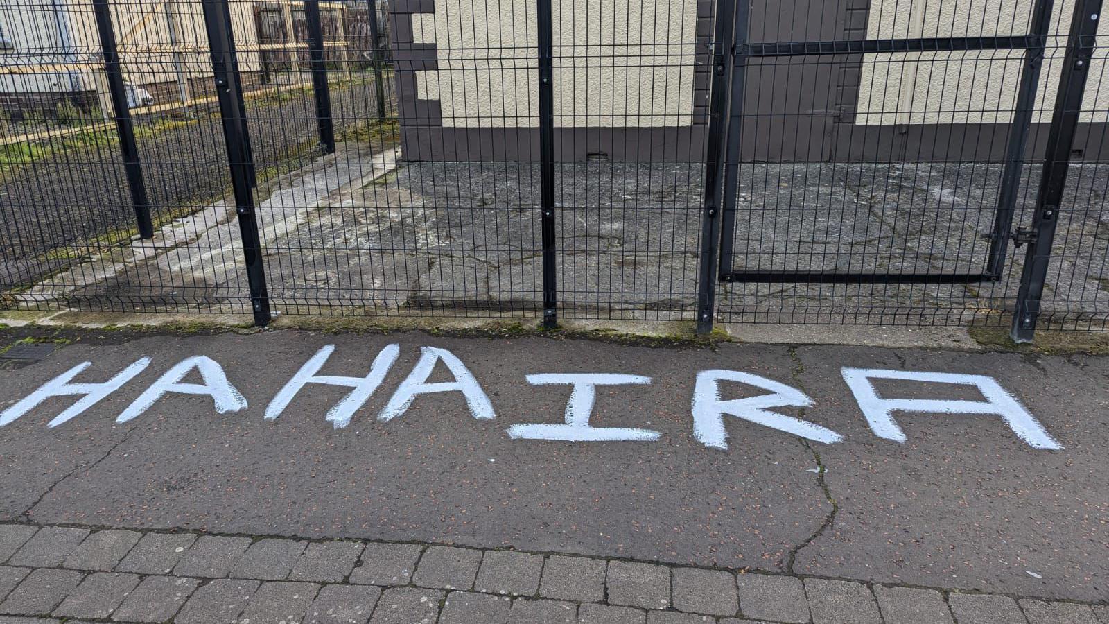 The words 'HAHA IRA' painted on the pavement outside the Orange Hall