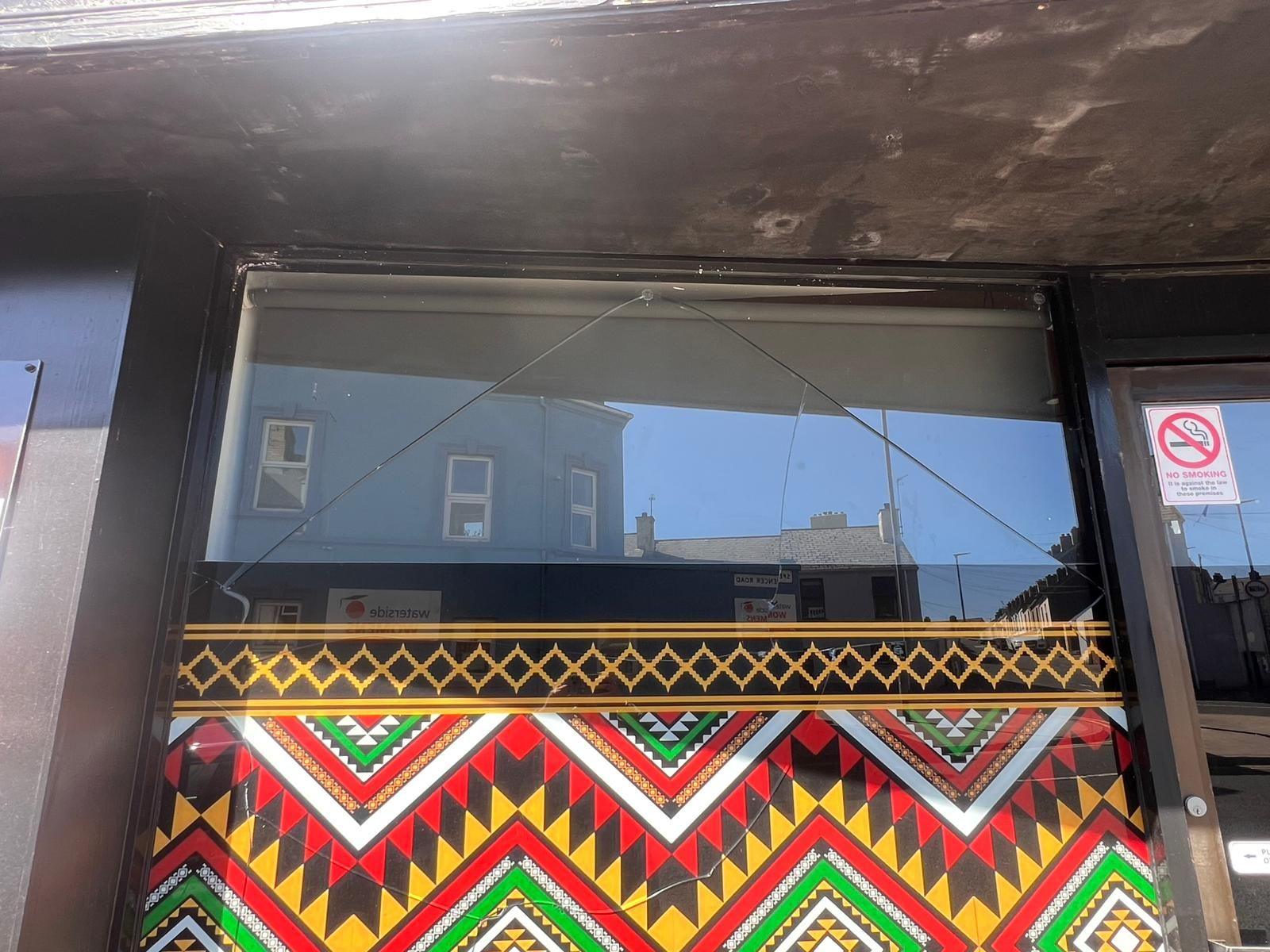Shows damage to a window which is painted in bright colours