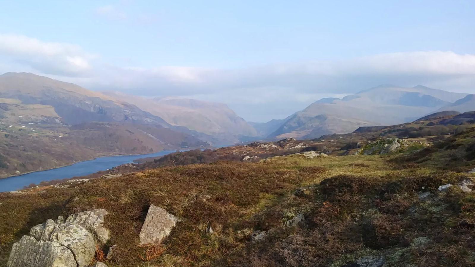 Dyffryn Peris, lle mae'r nofel wedi ei gosod, gyda chwarel Dinorwig a'r Wyddfa yn y pellter