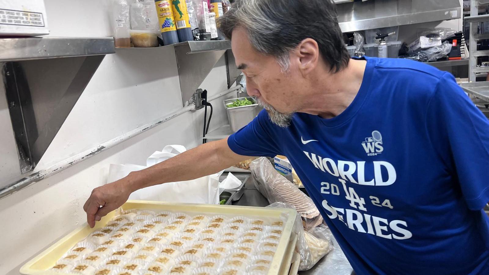 Don Tahara readies a large tray mochi - Japanese rice cakes - for those in his bar. Each cake is emblazoned with the Los Angeles Dodgers logo. 