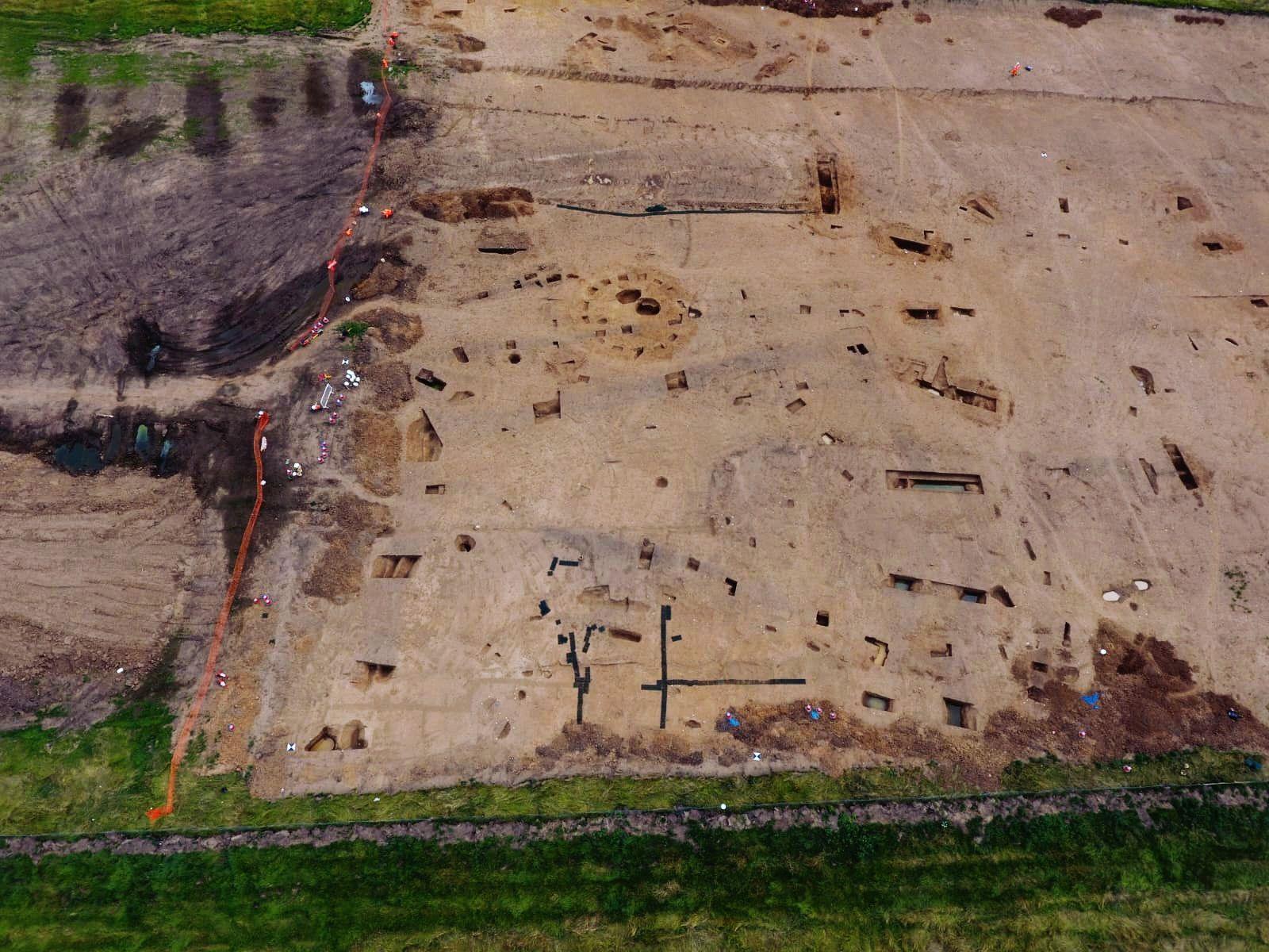 A drone shot of an excavation which includes a Late Iron Age to Early Roman roundhouse in the centre