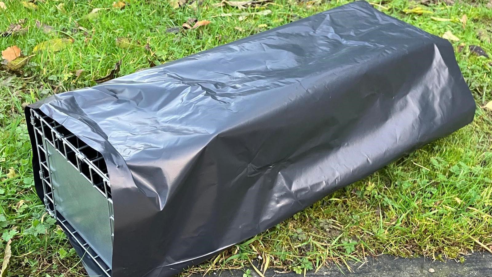 The picture shows a trap covered in black plastic, which is about two feet long and is used for trapping grey squirrels.