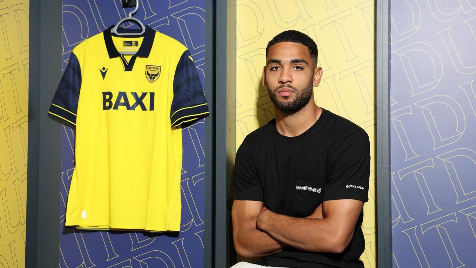 Brodie Spencer poses for a photo after signing with Oxford United