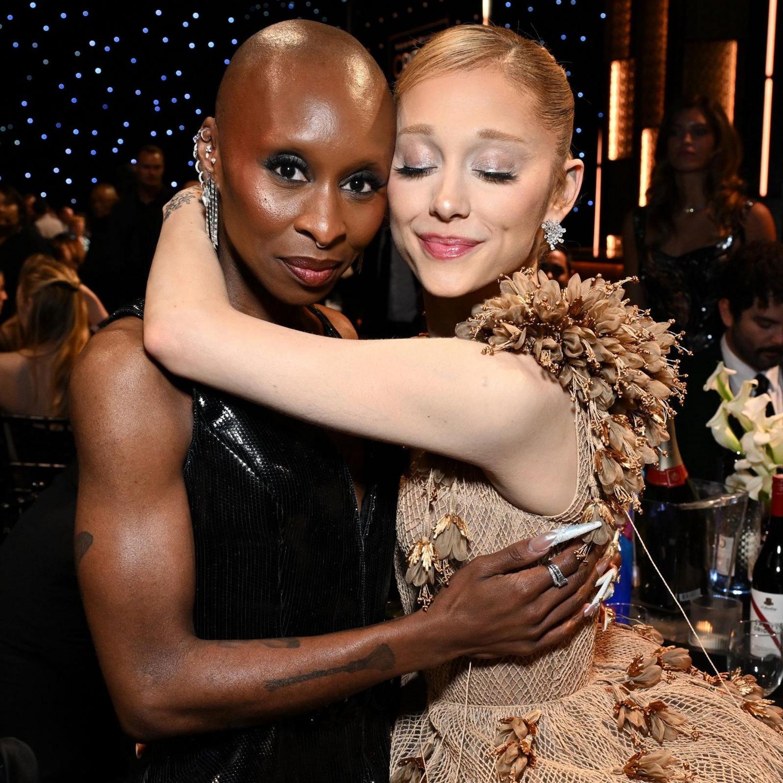 Cynthia Erivo and Ariana Grande embracing in evening dress