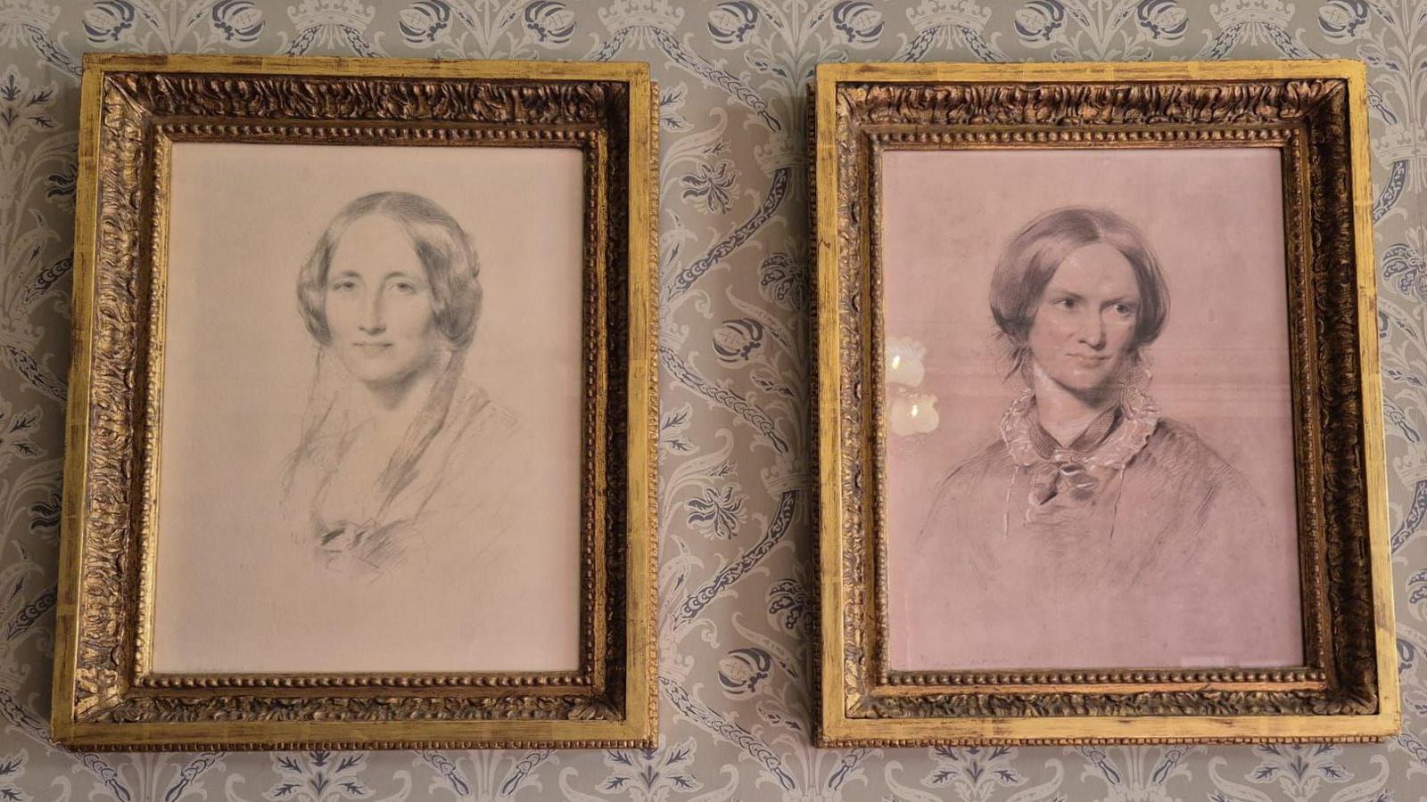 Framed charcoal portraits of Elizabeth Gaskell on the left and Charlotte Bronte on the right on the wall in the house