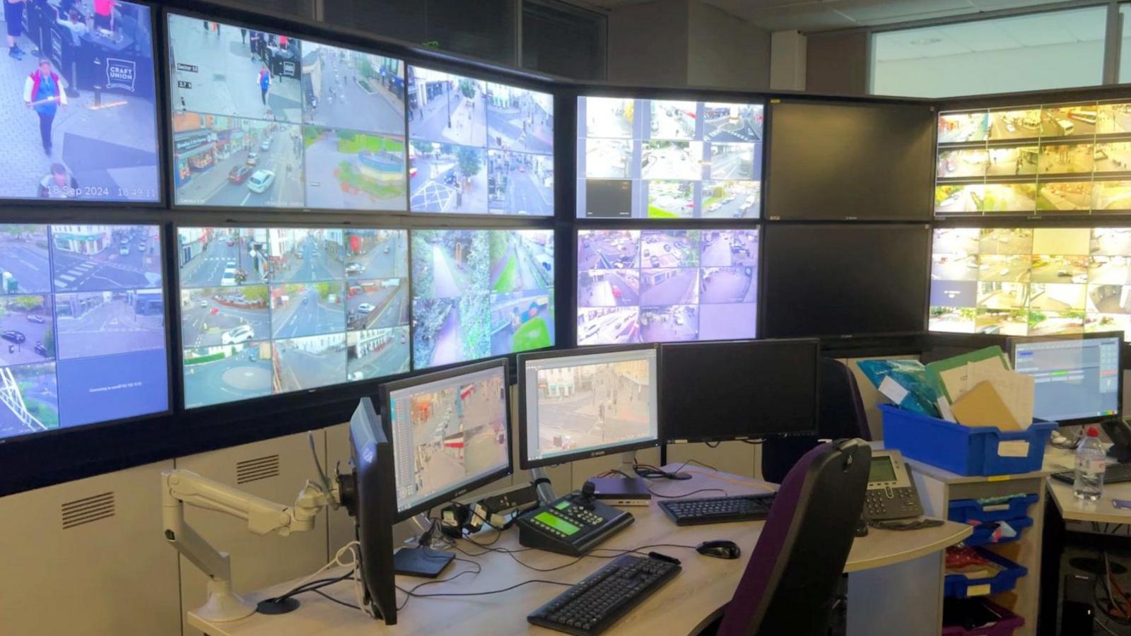 Gloucestershire Police's CCTV control room, showing a bank of computer monitors in front of a desk