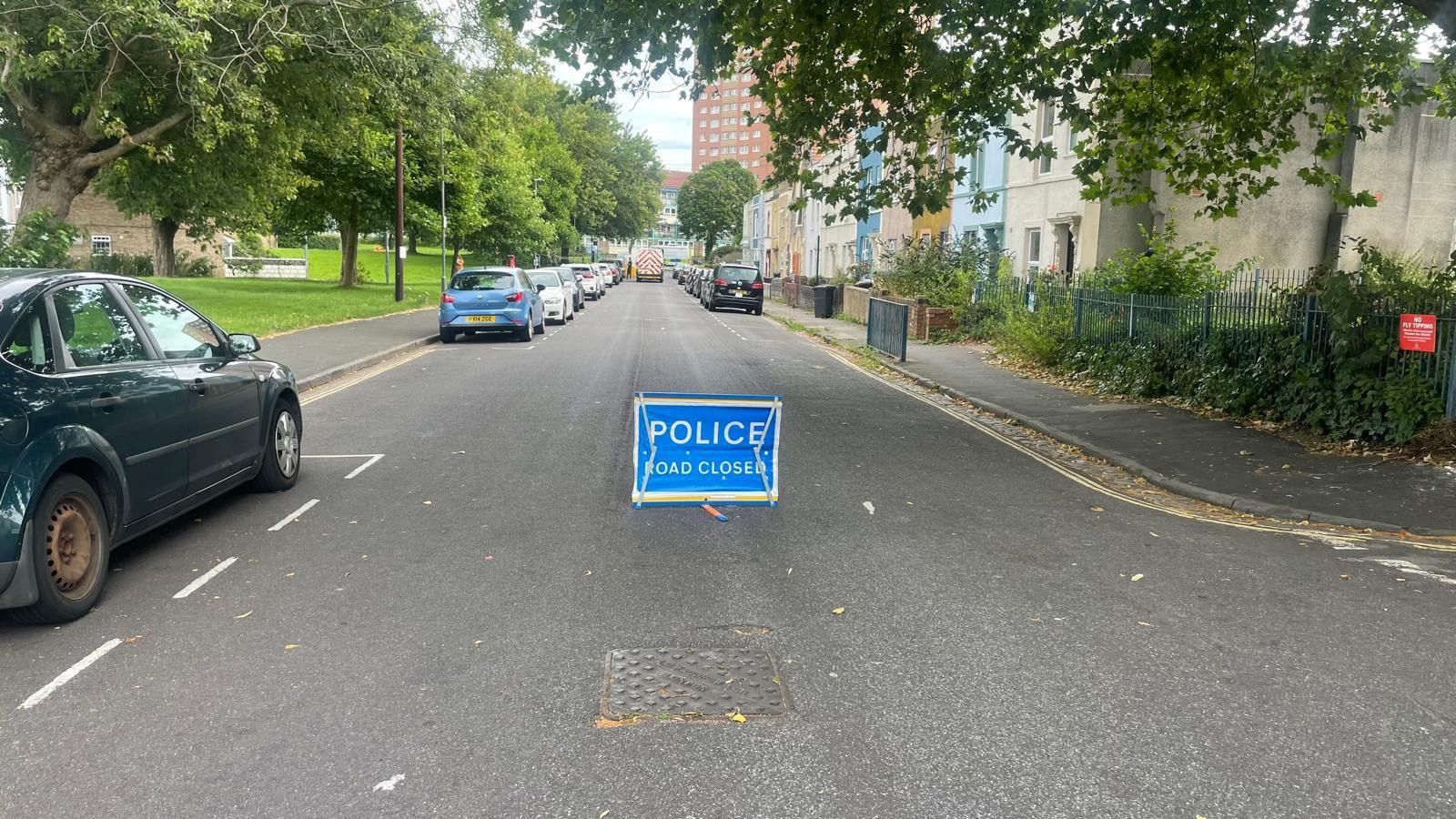 A sign on a road saying police road closed