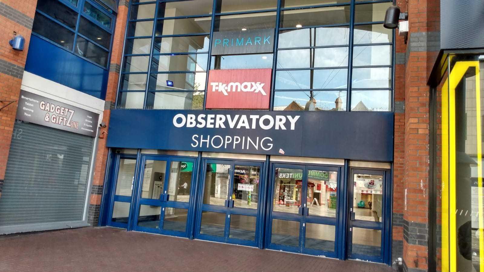 A row of three double glass doors with a blue and white sign above them saying 'Observatory shopping".