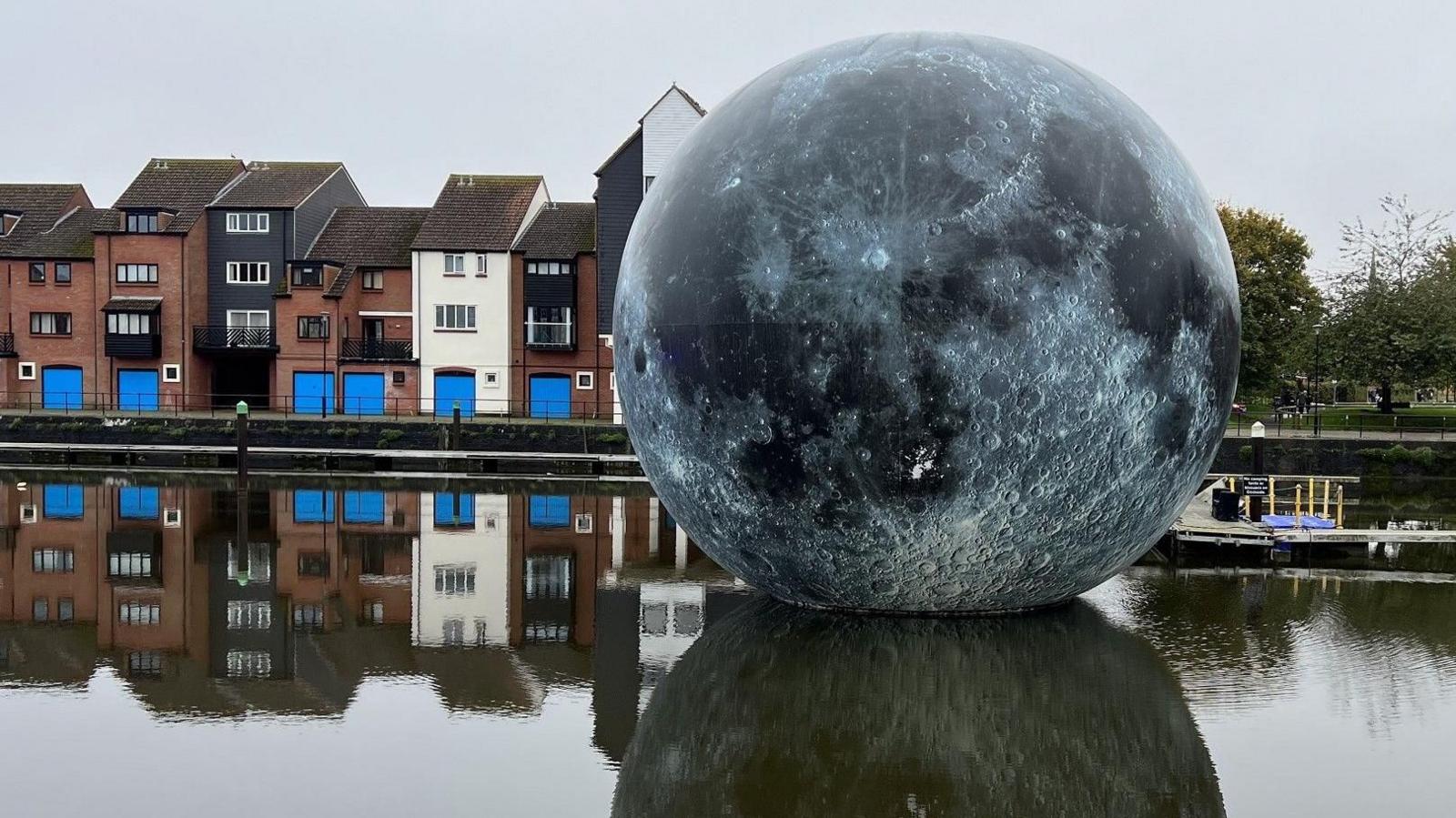 The Fallen Moon display, which is a large moon based on NASA data, floating on water in Bridgwater's docks