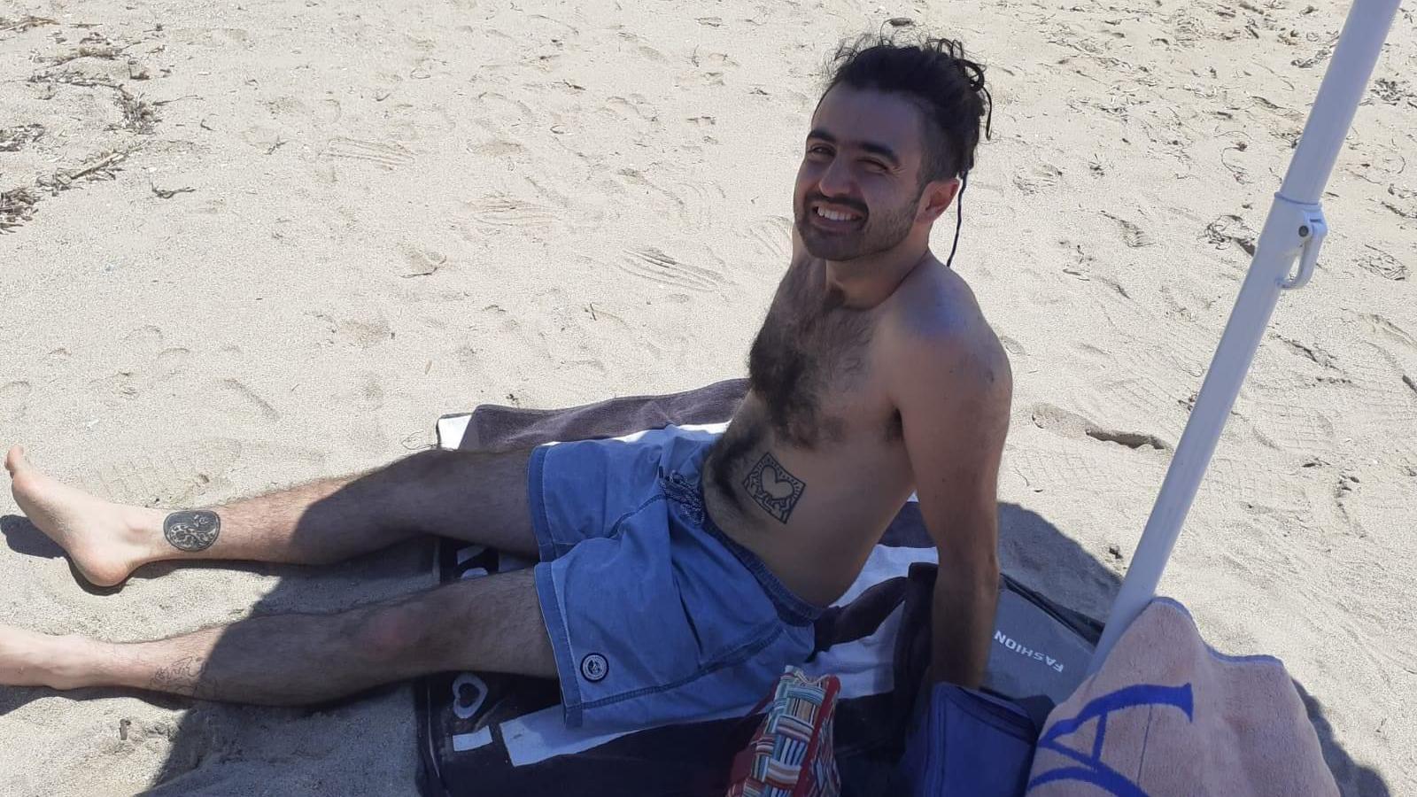 A man sitting under the shade on a beach