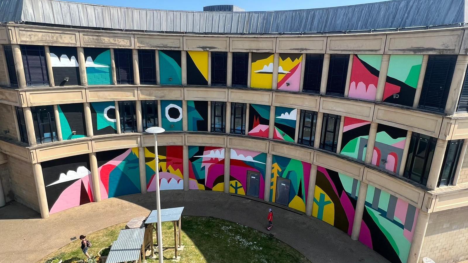 A building with its window panes painted many different colours