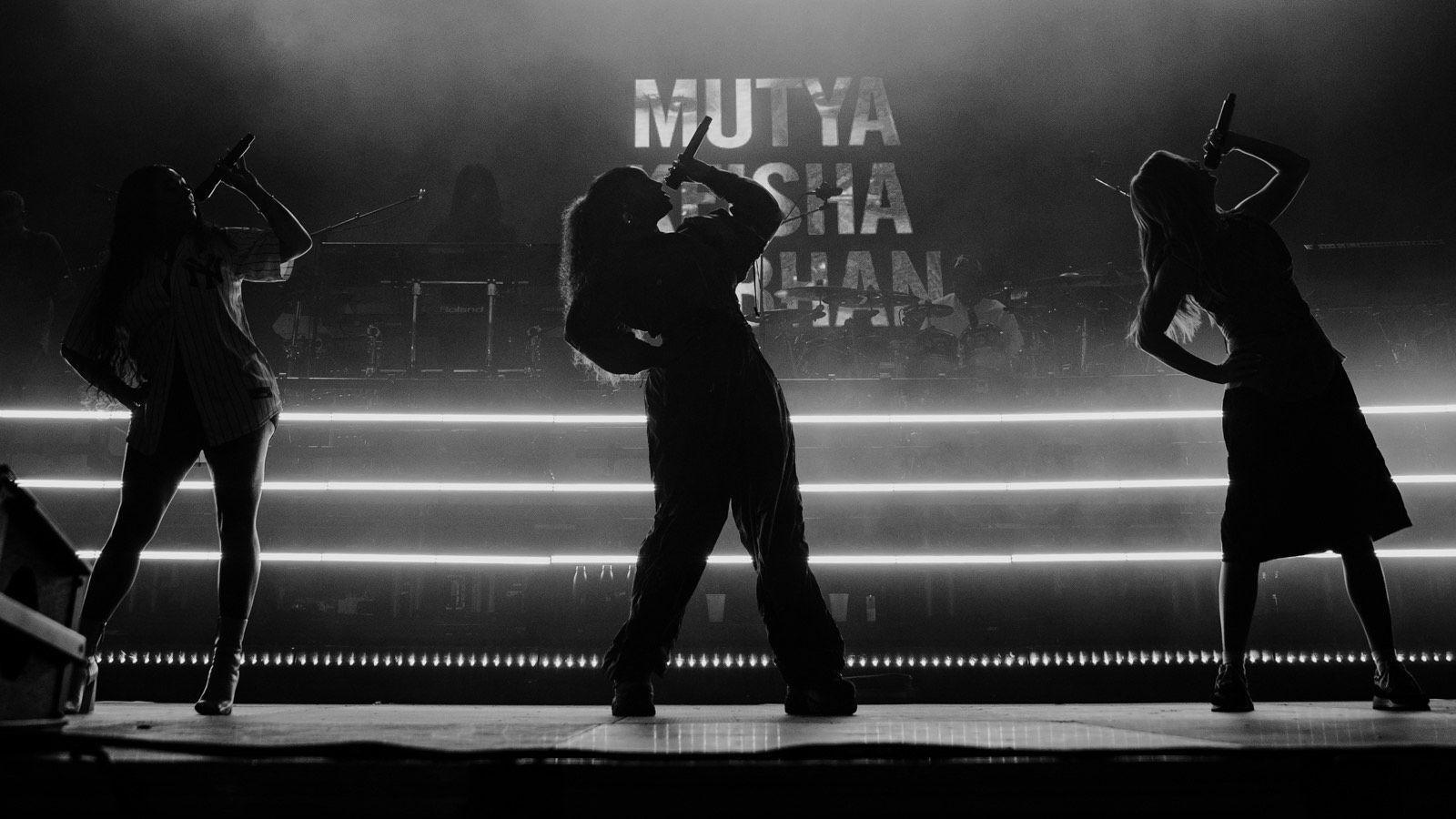 The three members of the band Sugababes silhoutted on stage in Bristol