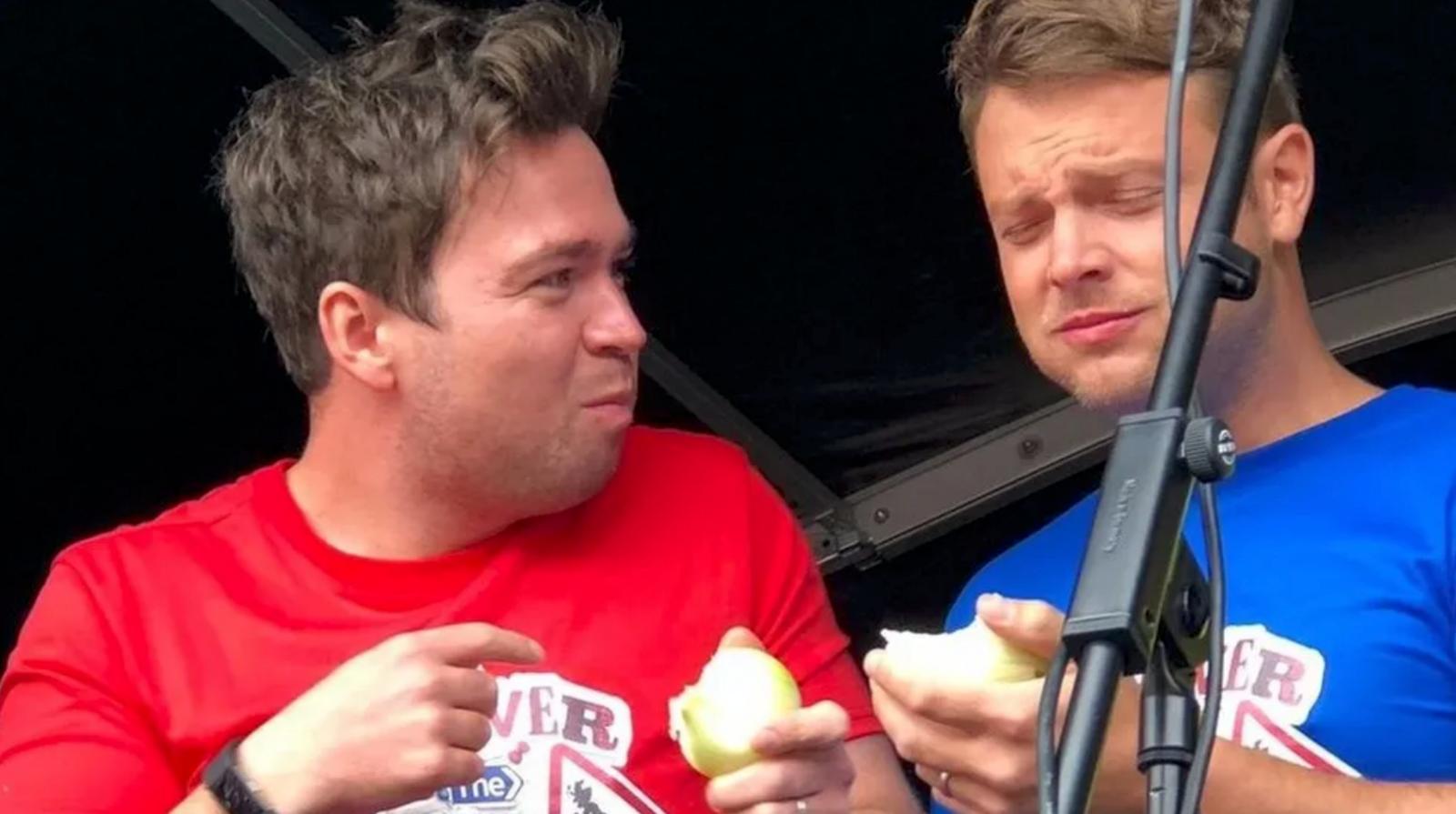 Two friends eating an onion