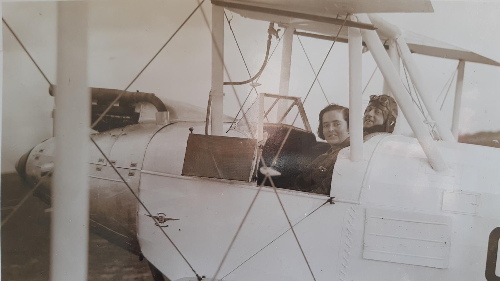 Flight Captain Susan Slade next to a co-pilot in an open cockpit of an aeroplane.