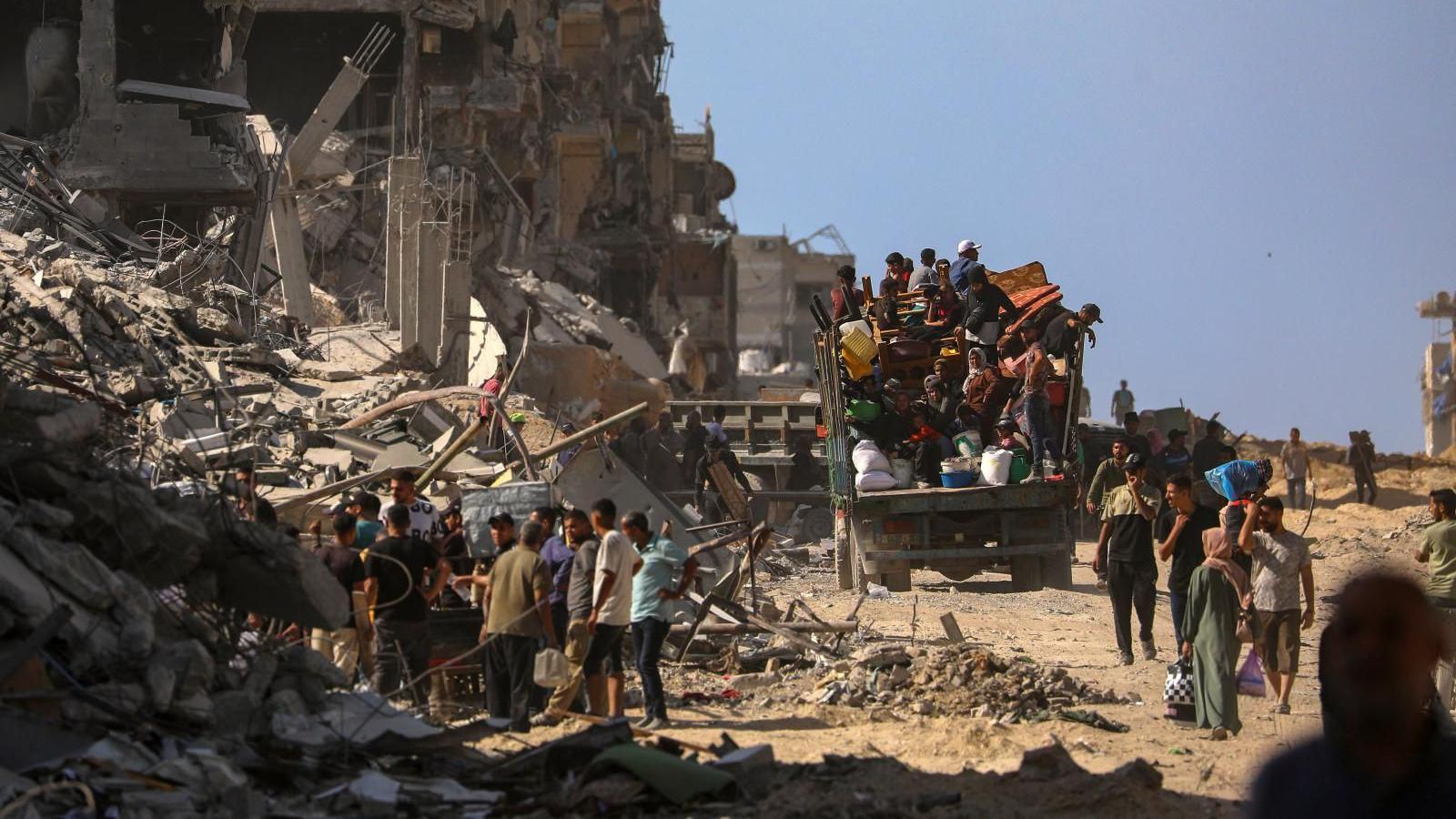 Internally displaced Palestinians walk along a street among the rubble of destroyed buildings amid a ceasefire between Israel and Hamas, in Gaza City.