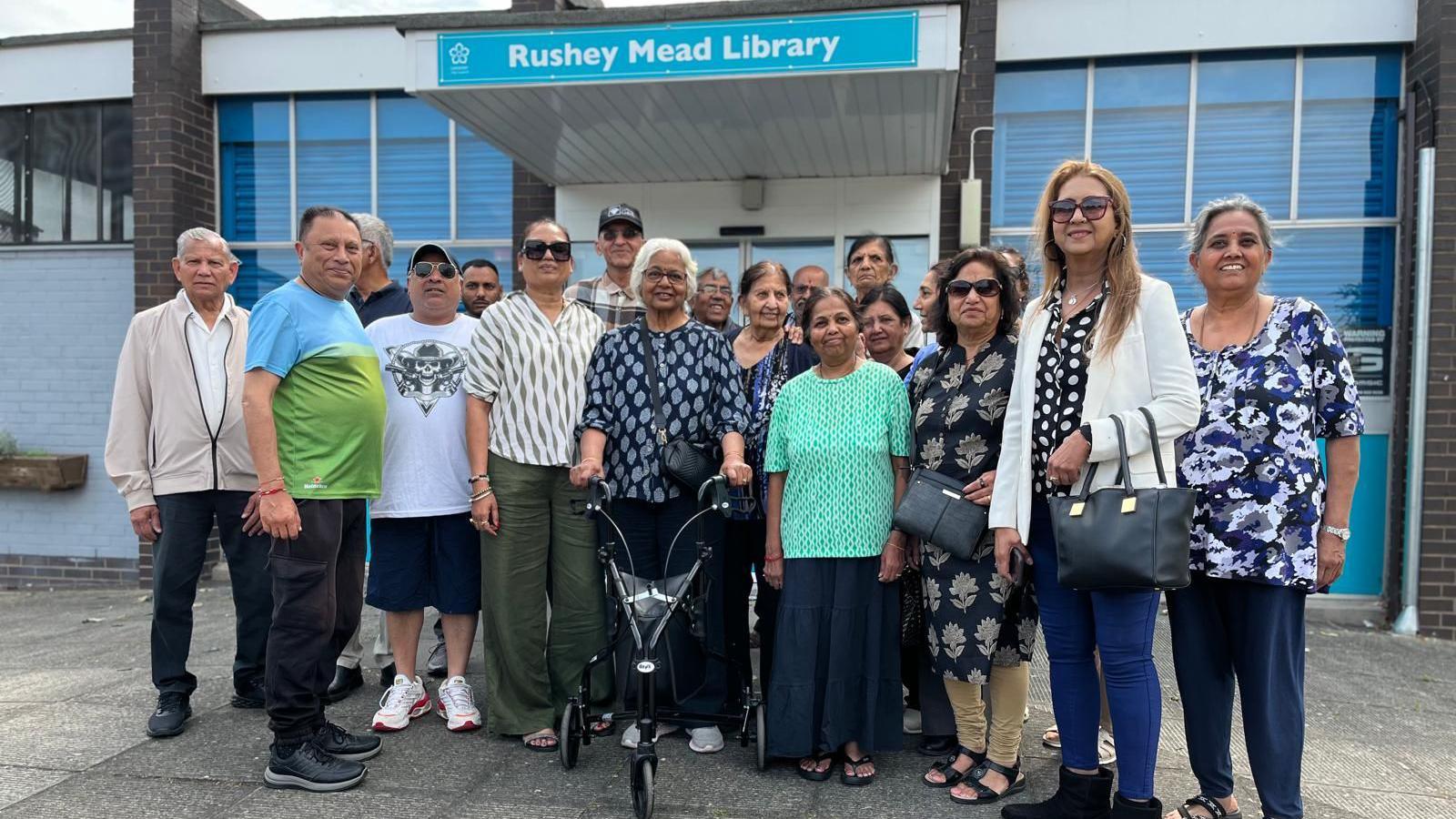 A group of men and women outside a library
